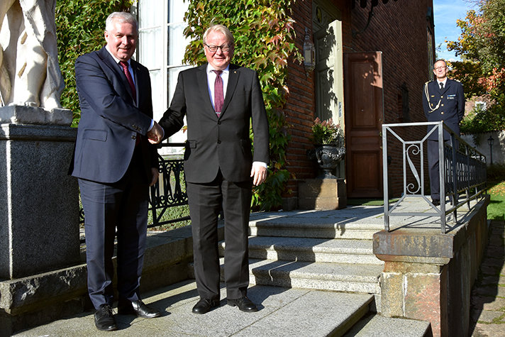 Peter Hultqvist and Arvydas Anušauskas shaking hands outside.