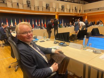 Peter Hultqvist is sitting  at a conference table. In front of him is a computer. 