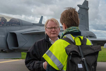 Peter Hultqvist standing outside being interviewed in front of a plane.