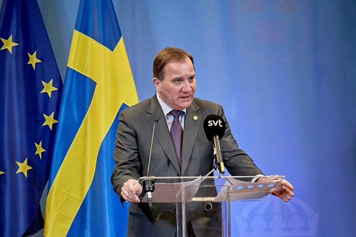 Prime Minister Stefan Löfven is standing in front of journalists during a press conference.