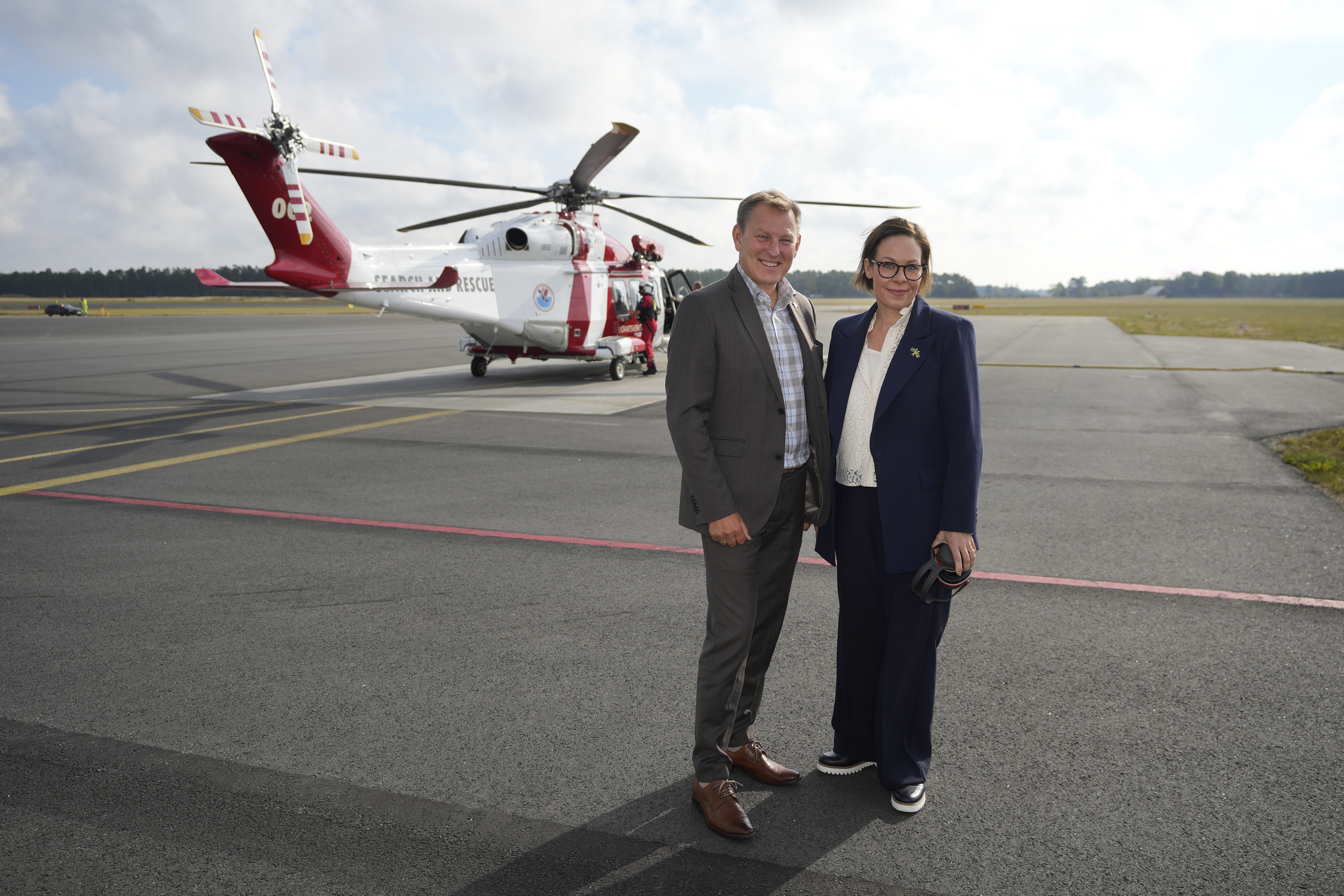 Minister for Foreign Affairs Maria Malmer Stenergard and the Swedish Maritime Administration's Director General Erik Eklund standing in front of a helicopter
