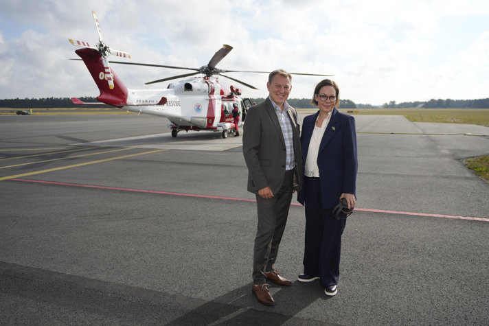 Minister for Foreign Affairs Maria Malmer Stenergard and the Swedish Maritime Administration's Director General Erik Eklund standing in front of a helicopter