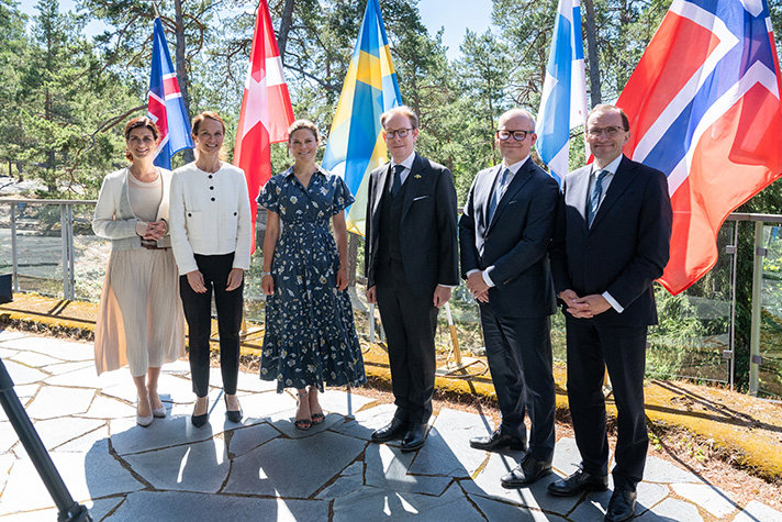 Group picture in front of the nordic flags, outside