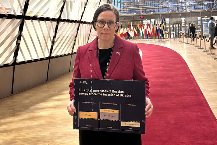 Maria Malmer Stenergard holding up a sign with graphs and the text "EU's total purchases of Russian energy since the invasion of Ukraine".
