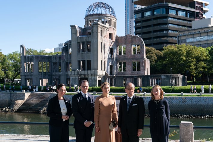 Crown Princess Victoria and Prince Daniel and Minister for Foreign Affairs Maria Malmer Stenergard togheter with the Mayor of Hiroshima Kazumi Matsui and Swedish Ambassador to Japan Viktoria Li posing in front of ruins.
