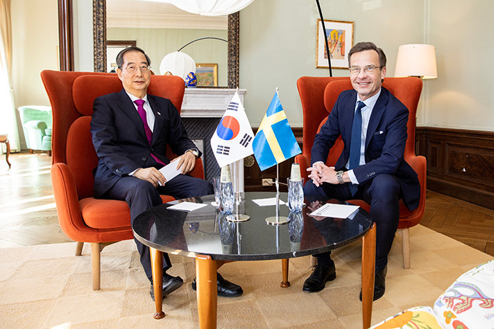 Han Duck-Soo och Ulf Kristersson sitter i varsin fåtölj i Sagerska huset. Framför dem står ett bord med den sydkoreanska och den svenska flaggan.